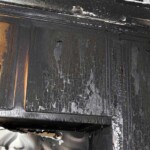 Soot and smoke residue buildup inside fireplace after fire damage
