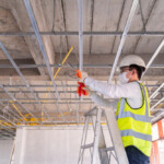 Technician inspecting ceiling framework during commercial restoration project